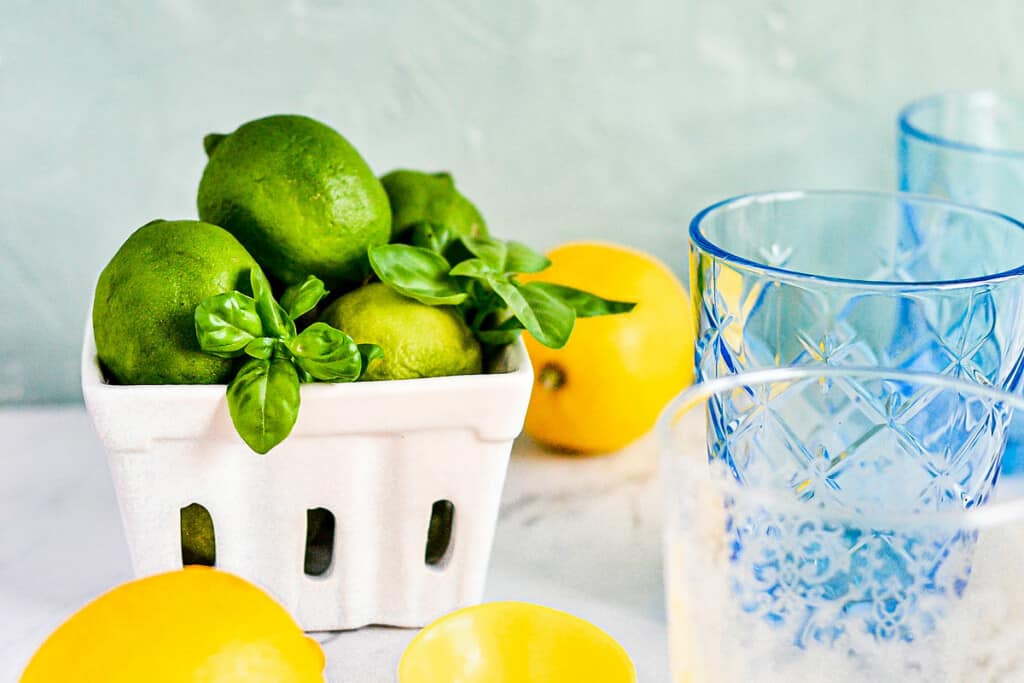 limes and basil in fruit container