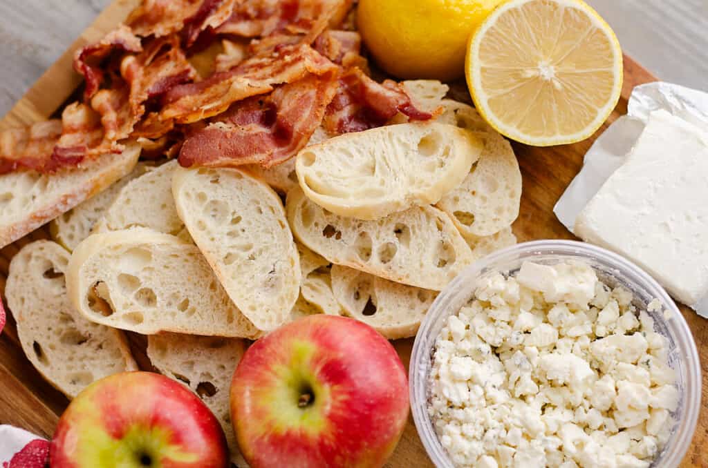 bacon, crostini, apples, bleu cheese and cream cheese on cutting board