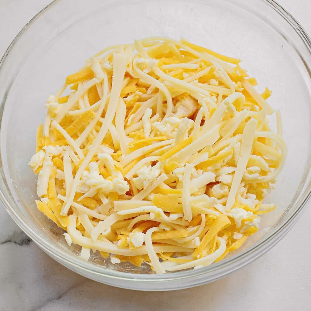 shredded cheese in glass bowl