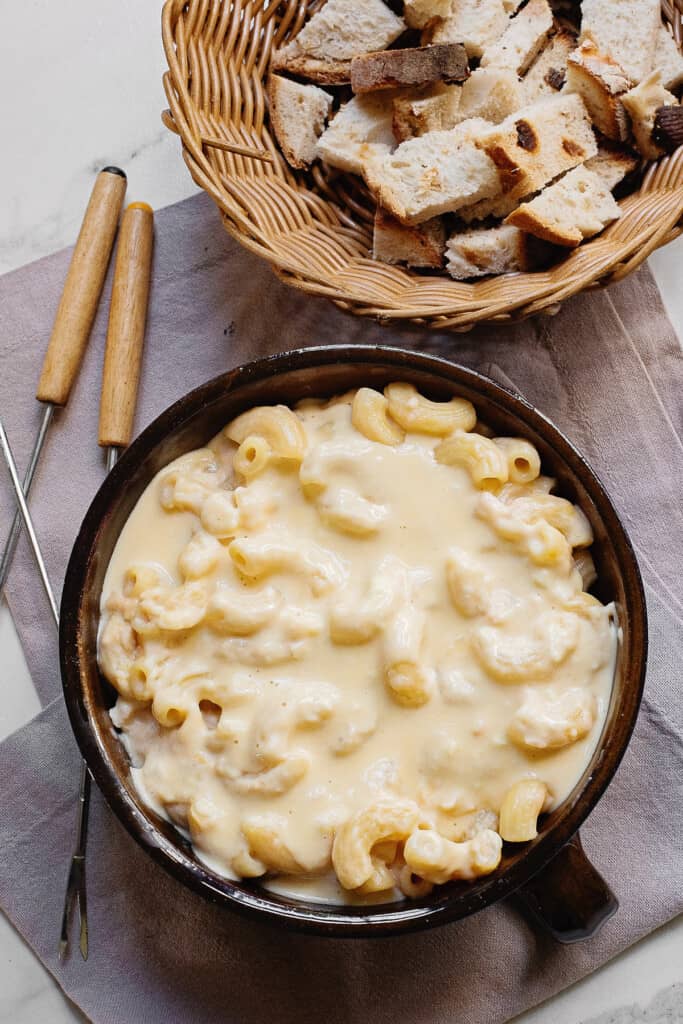 table with mac and cheese fondue and crusty basket of bread cubes