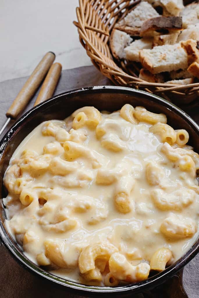 fondue pot with macaroni and cheese fondue on table