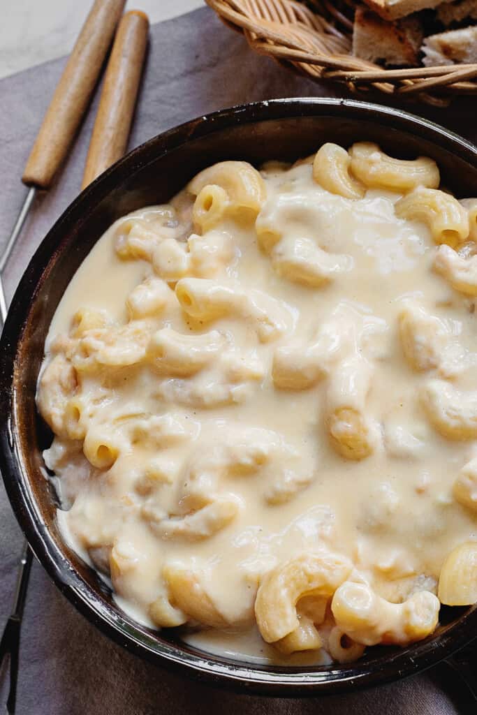 cheesy macaroni fondue in dish with fondue forks