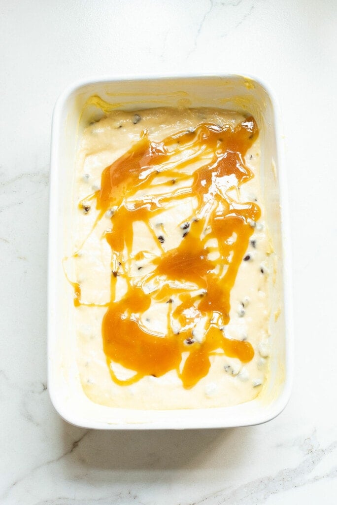 chocolate chip coffee cake batter in pan drizzled with caramel