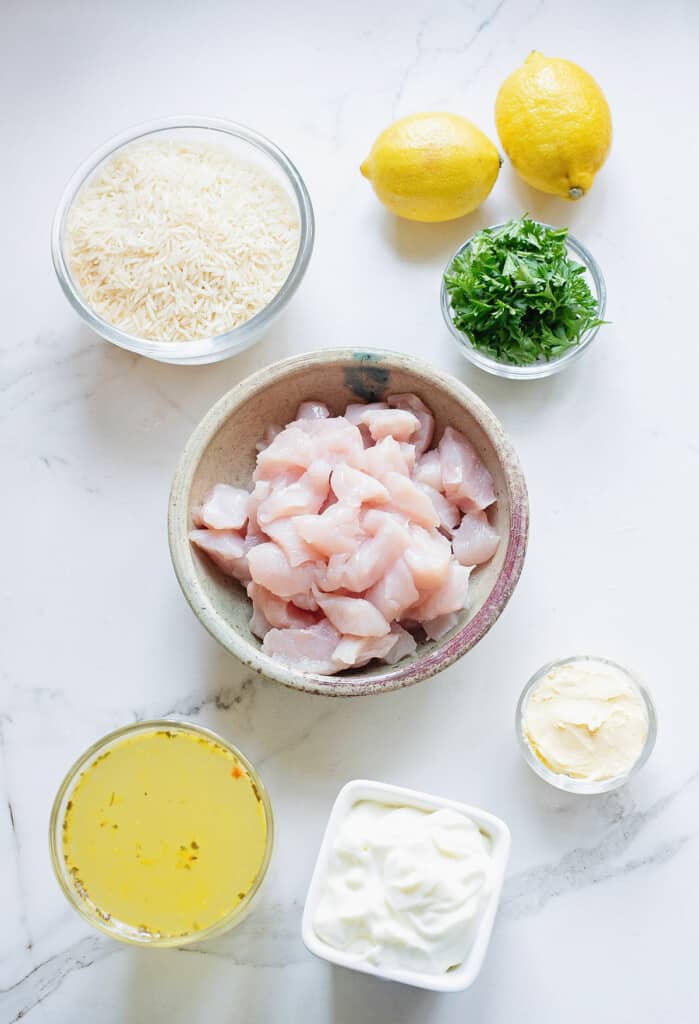 ingredients for baked lemon chicken and rice on marble table