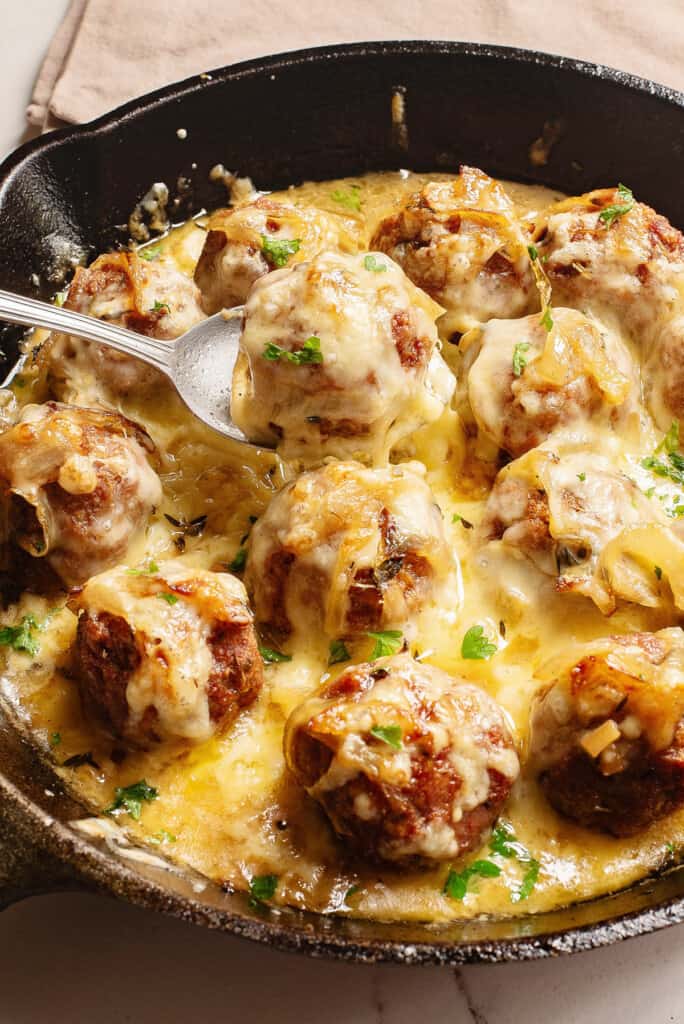 French Onion Meatball in spoon over skillet