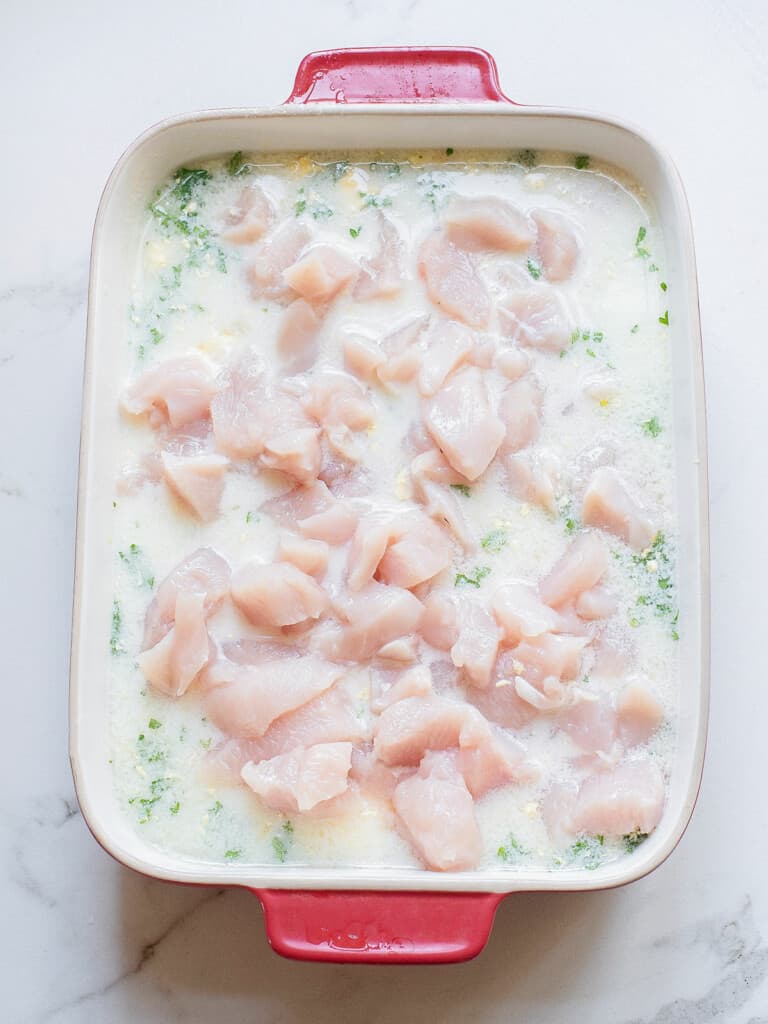 creamy lemon rice topped with chicken breasts in baking dish