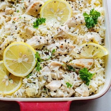 baked chicken and rice in pan topped with lemon slices