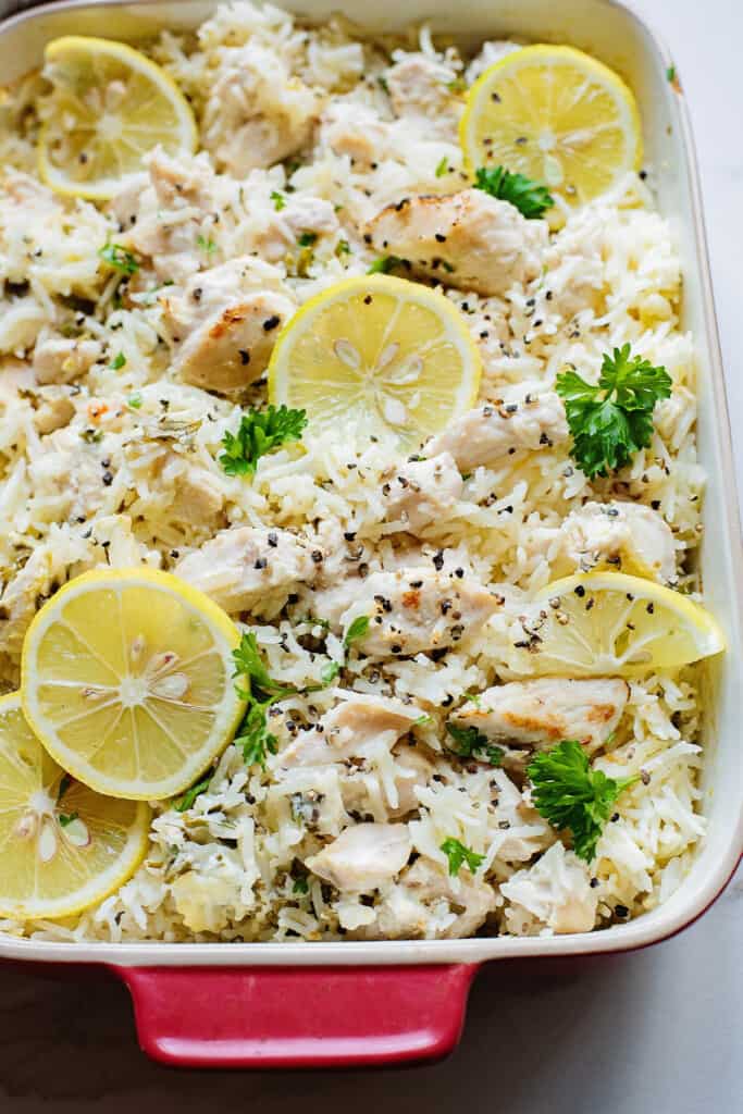 baked chicken and rice in pan topped with lemon slices