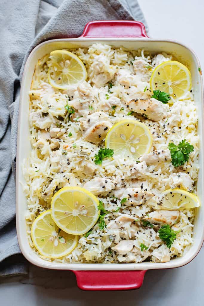 9x13 pan with baked chicken and rice topped with lemons