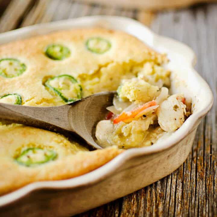 small casserole pan scooped with chicken verde and cornbread casserole