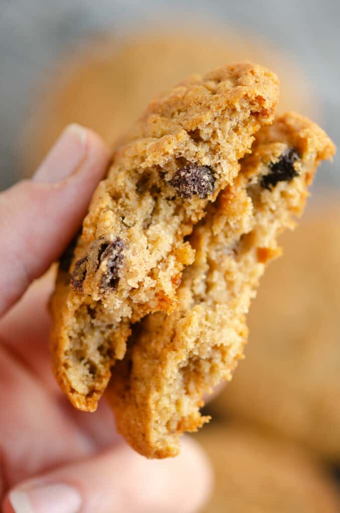 oatmeal raisin cookie broken in half in hand