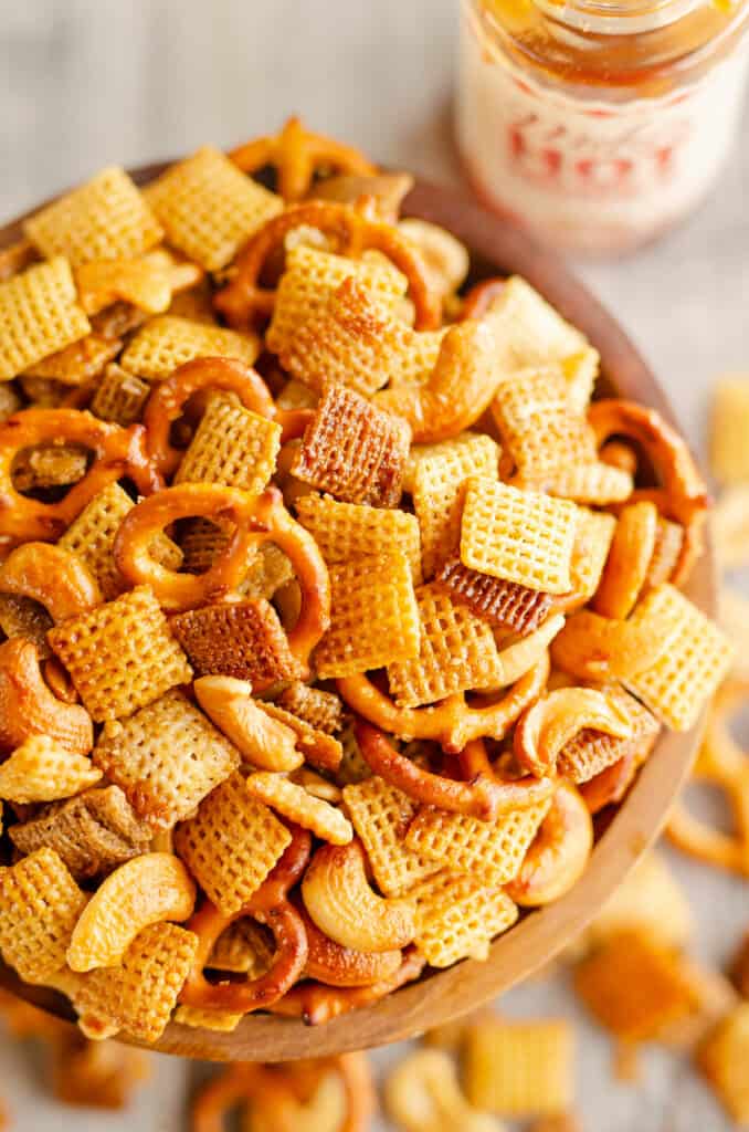 bowl of hot honey snack mix on table with bottle