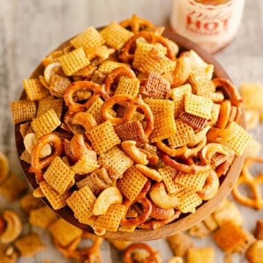 snack mix in bowl with botte of hot honey