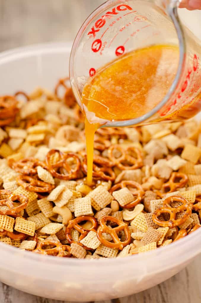 chex mix with hot honey butter sauce poured over it in large bowl