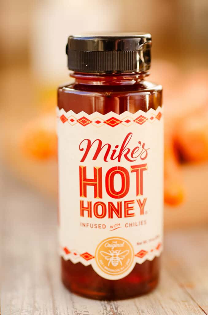 bottle of mike hot honey on table with carrots