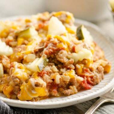 Cheeseburger Rice casserole on plate topped with pickles