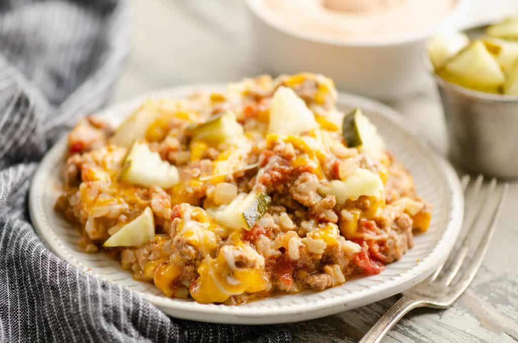 Cheeseburger Rice casserole on plate topped with pickles