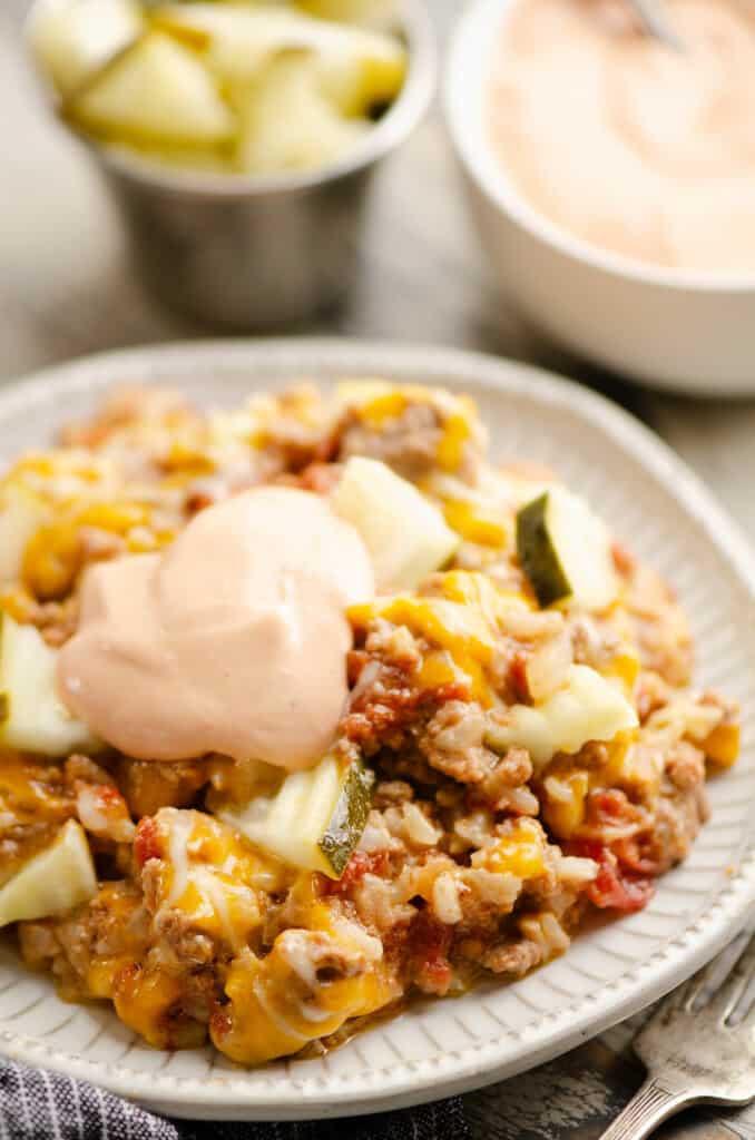 Cheeseburger Rice casserole on plate topped with dollop of special sauce