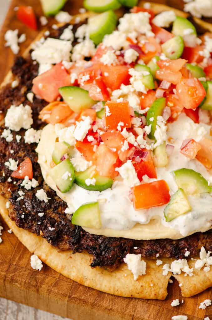 lamb smash gyro on table with hummus and tzatziki