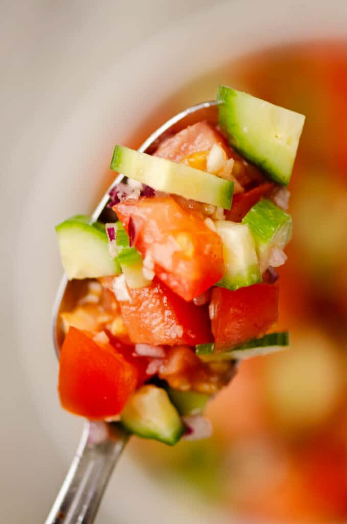 cucumber tomato salad on spoon