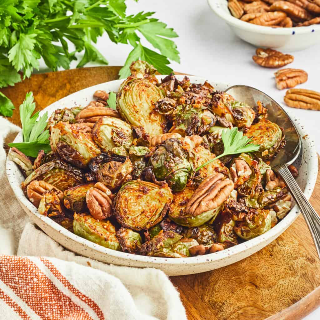 air fryer maple dijon and pecan brussels sprouts in bowl on cutting board