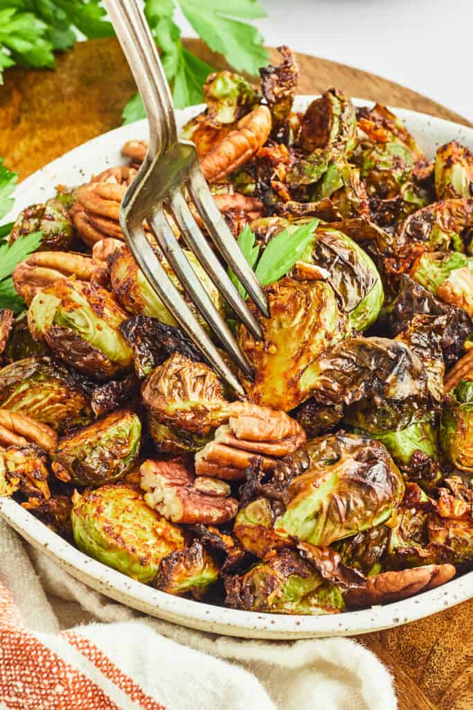 maple dijon and pecan brussels sprouts in bowl with fork
